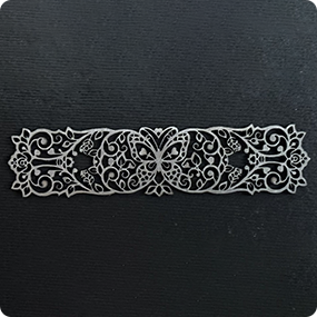 Fine laser engraving on black material with detailed ornamental pattern