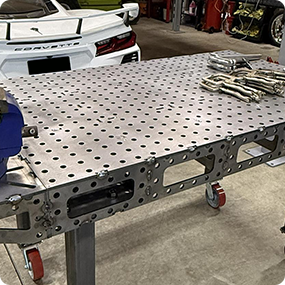 Custom laser cut metal parts arranged on a fabrication worktable