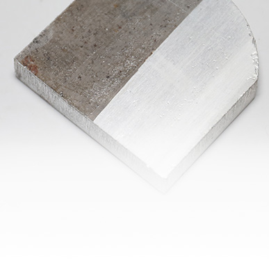 Metal sample showing untreated and treated surface areas for cleaning evaluation