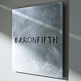 Laser cut metal nameplate with engraved branding detail