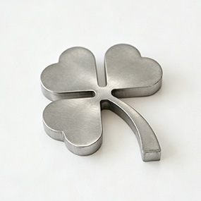 Custom shaped metal part produced by precision laser cutting